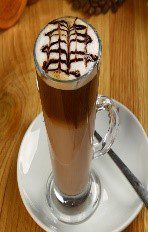 A cup of coffee with whipped cream and chocolate.