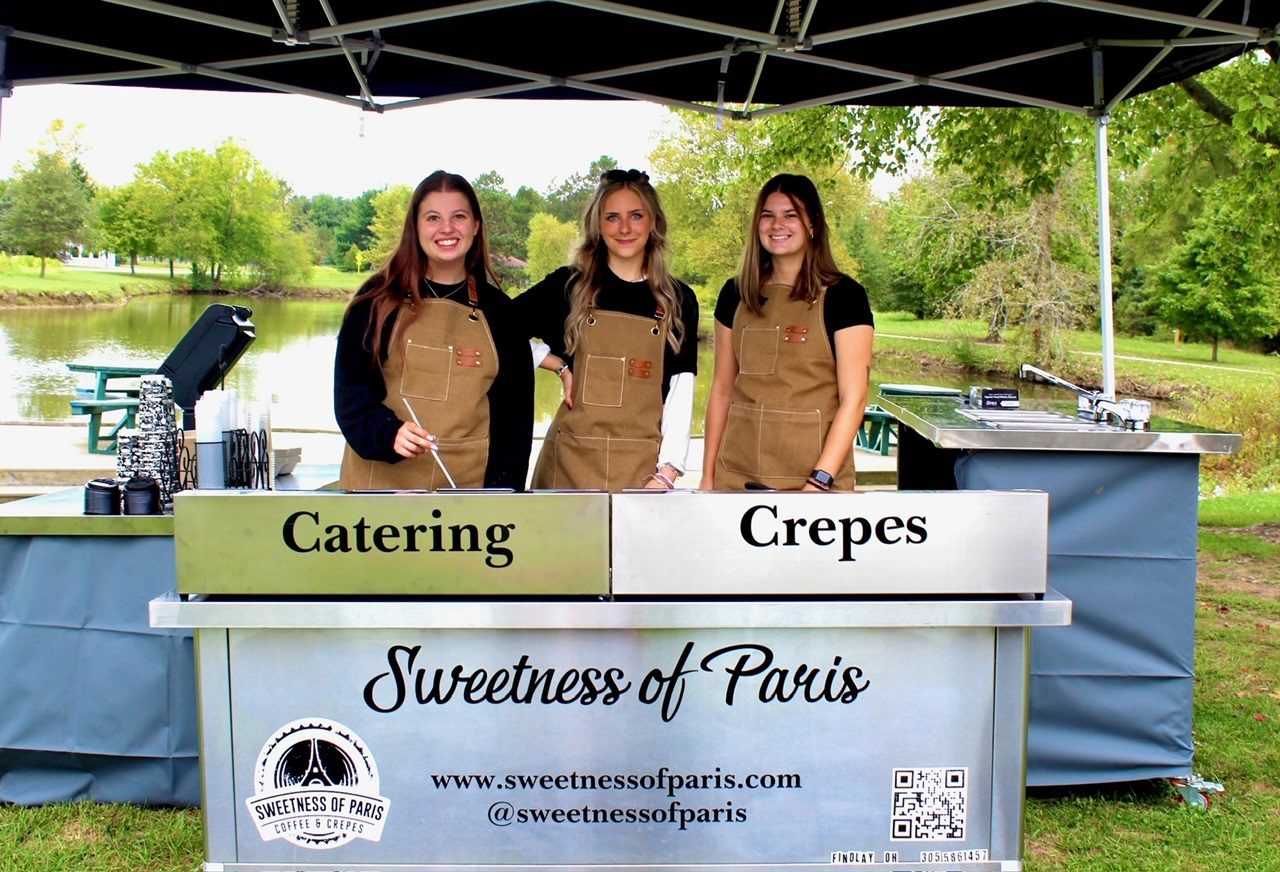 Three women standing in front of a tent.