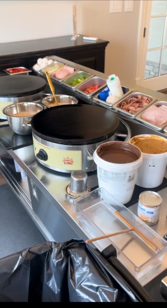 A counter with pots of food and sauces on it.