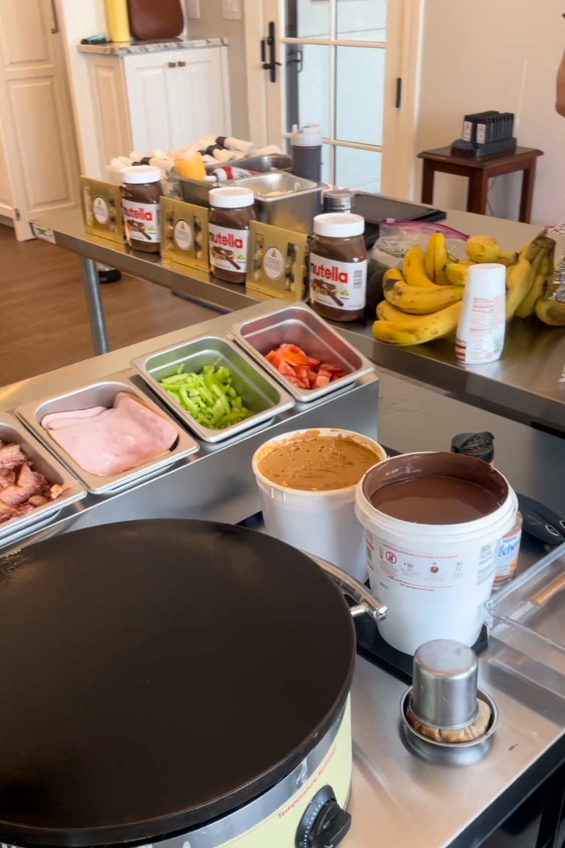 A counter with bowls of food and cups on it.